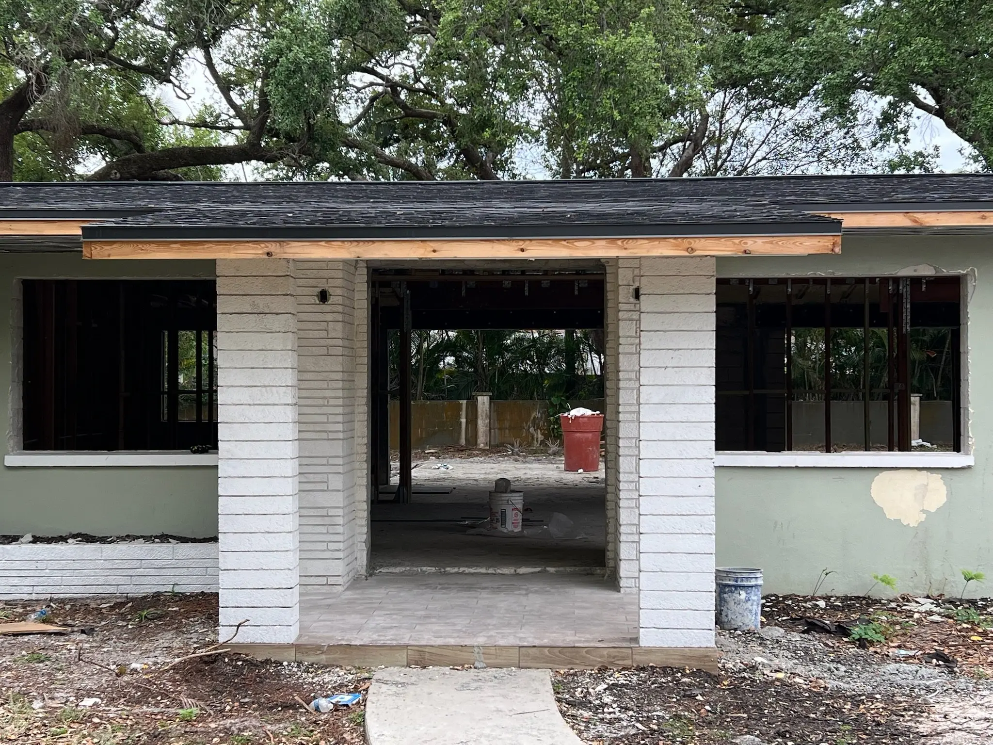 Before: the same home exterior gutted down to the block walls during renovation