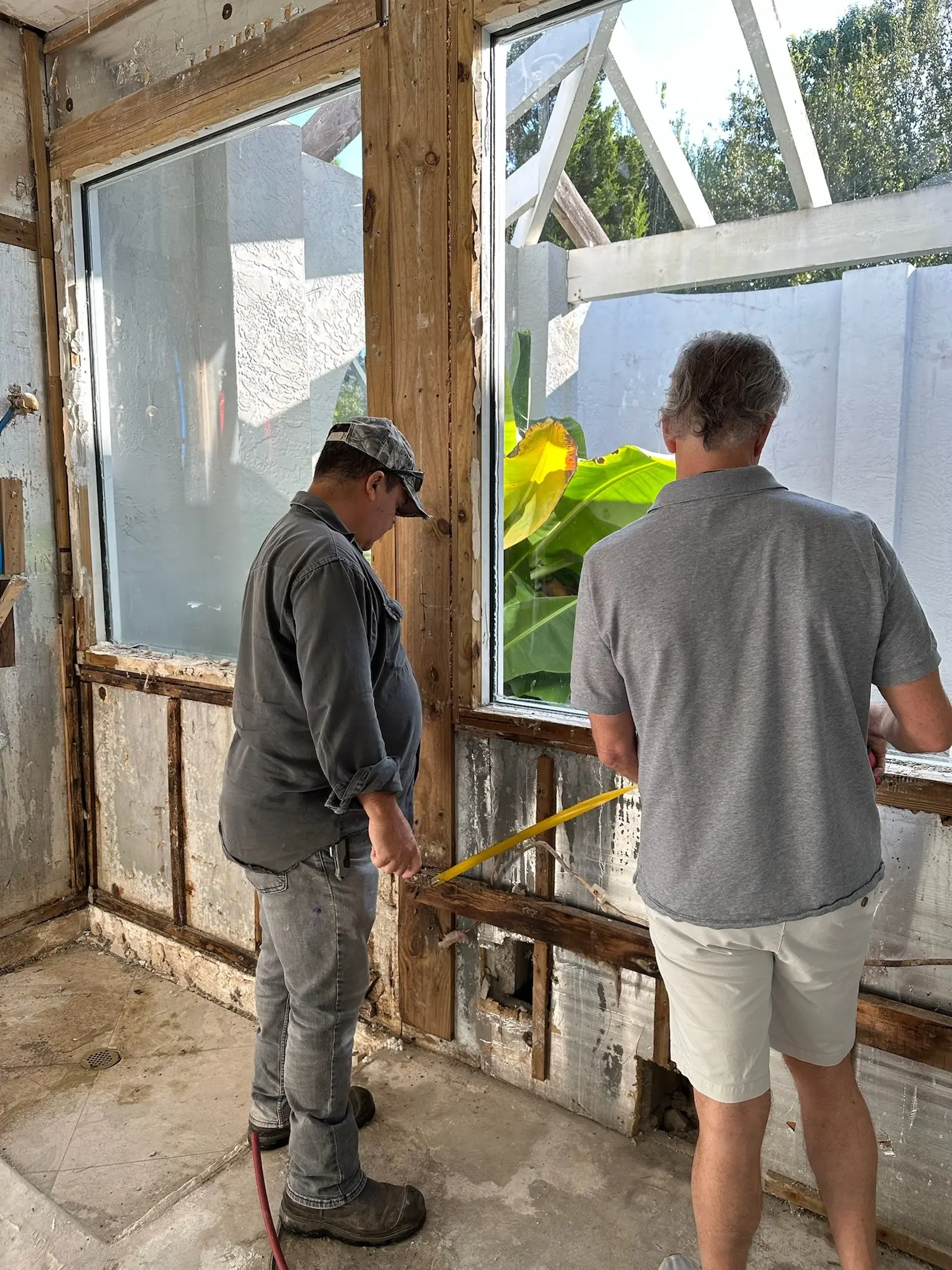 The Remodeling Company team measuring a bathroom renovation on a Southwest Florida job site